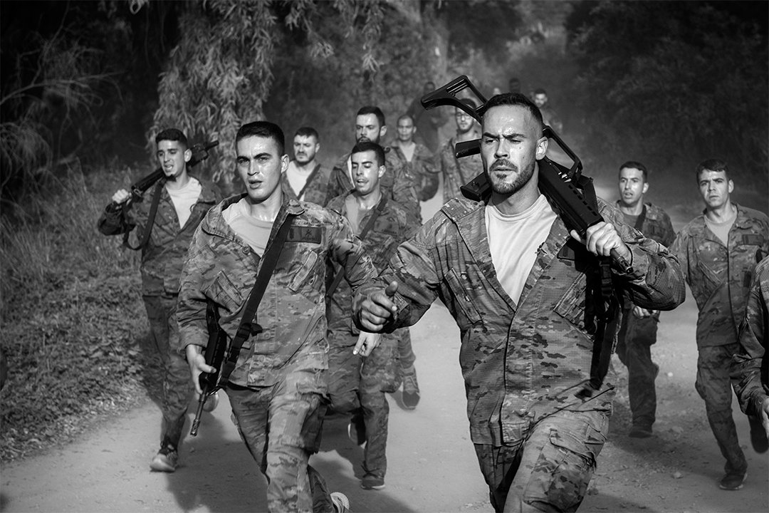 A group of service members running along a track.